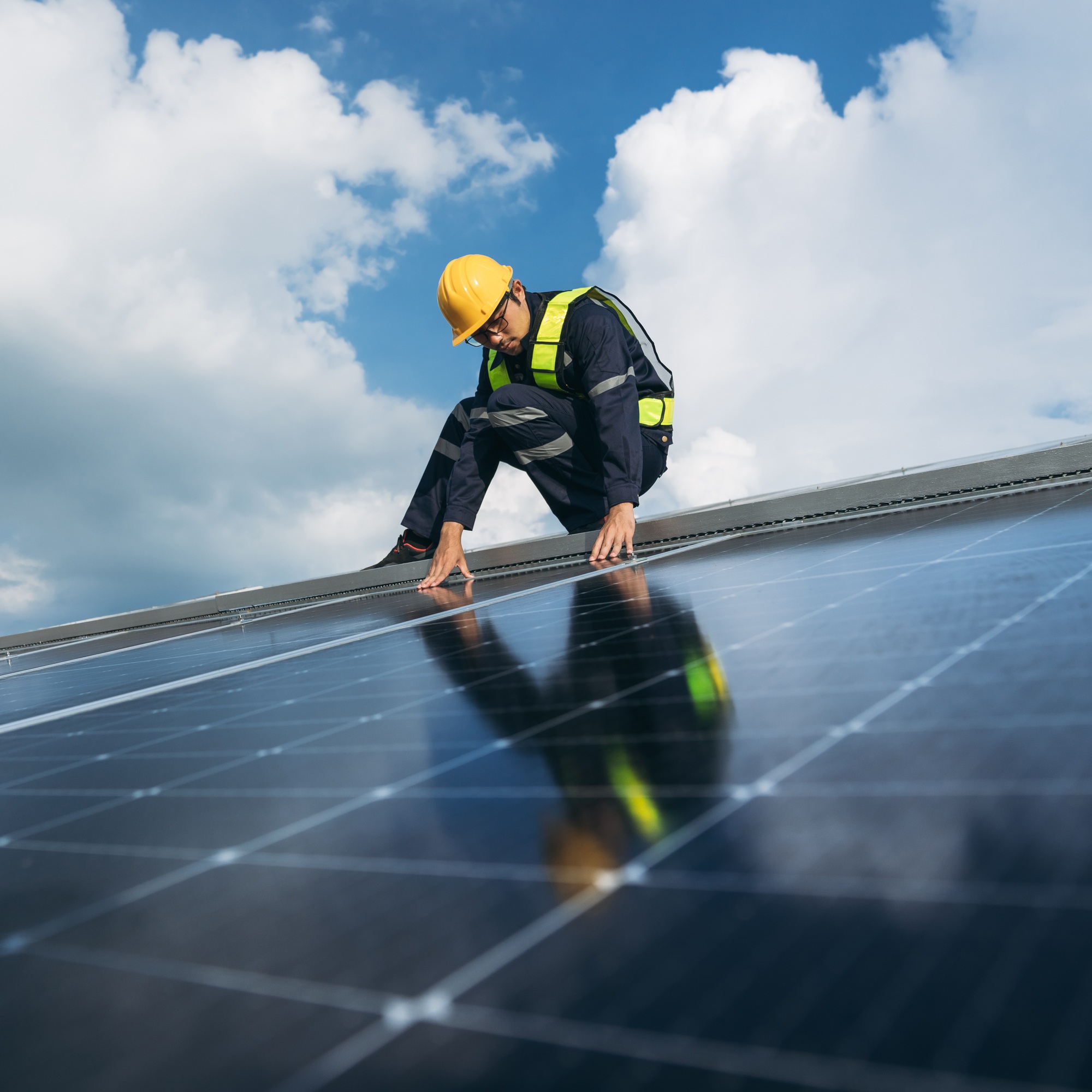 Service engineer checking solar cell on the roof for maintenance if there is a damaged part.