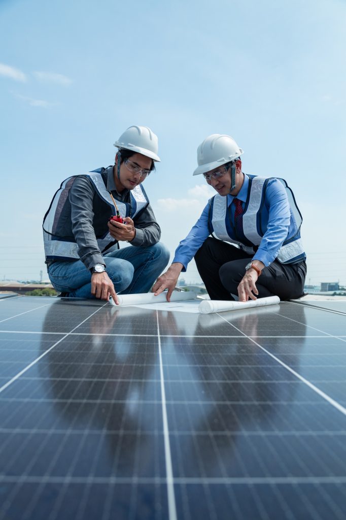 Engineers and solar panel technicians read installation location drawings and drill